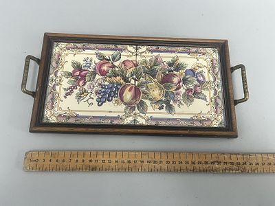 A rectangular serving tray with a dark brown wooden frame, brass-colored handles, and two 