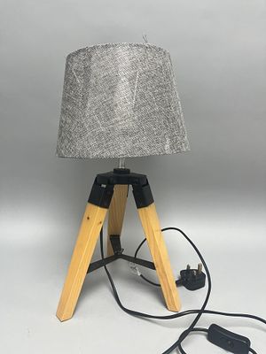 A contemporary table lamp featuring a tripod-style base composed of three light-colored wooden 