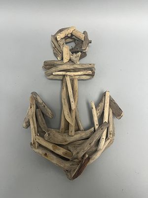 A contemporary decorative wall hanging, shaped like a ship's anchor, constructed from numerous 