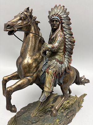 A Chief Sitting Bull on Horseback' sculpture. This bronze-finished resin sculpture portrays a 