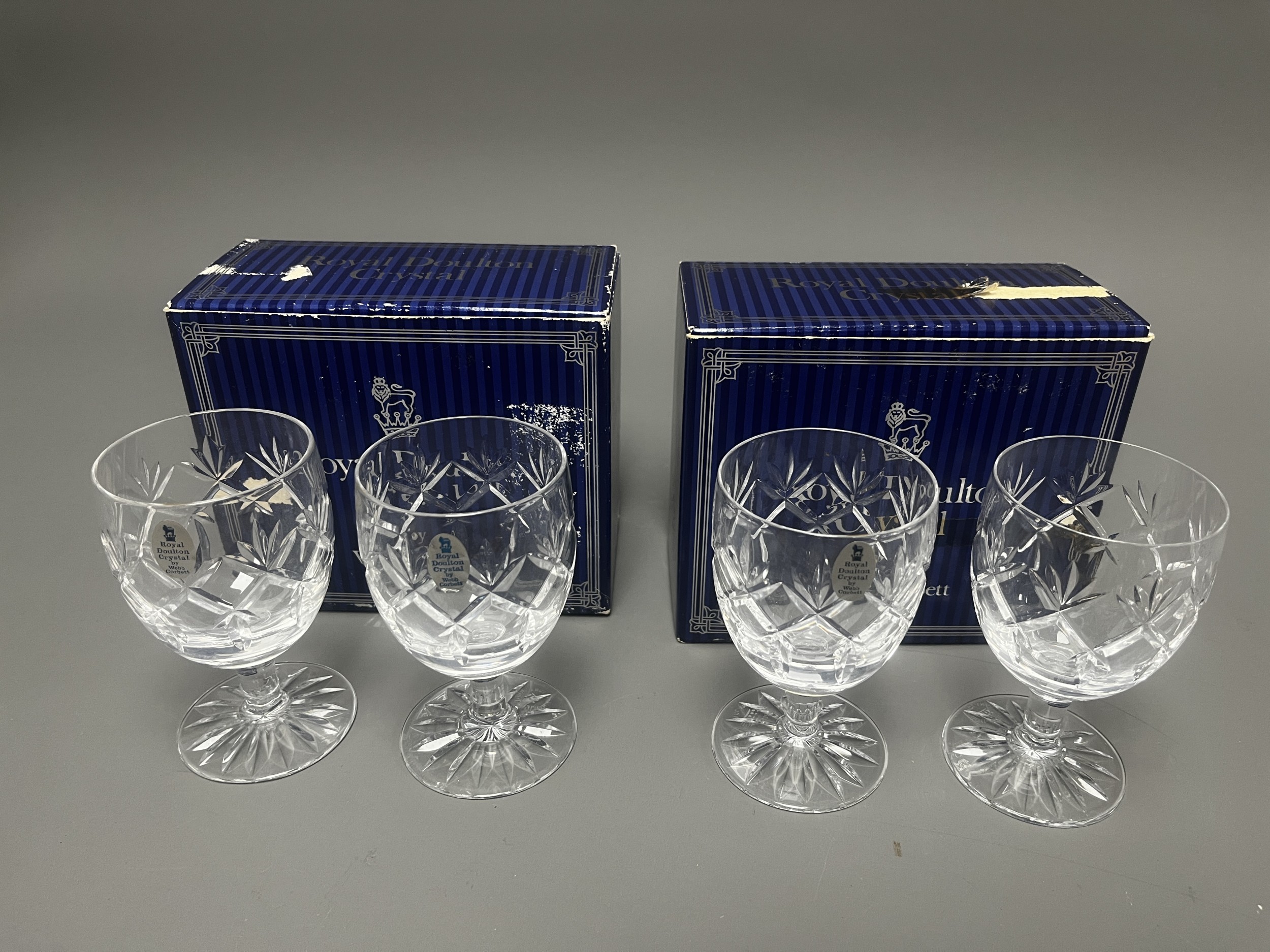 A set of four clear lead crystal glasses, likely wine glasses