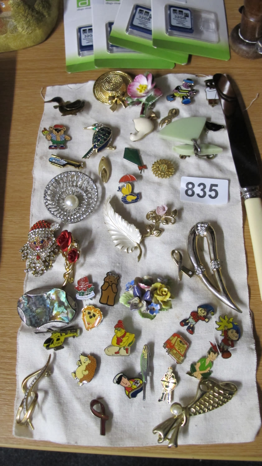 Lot 835: A collection of enamel badges and brooches.