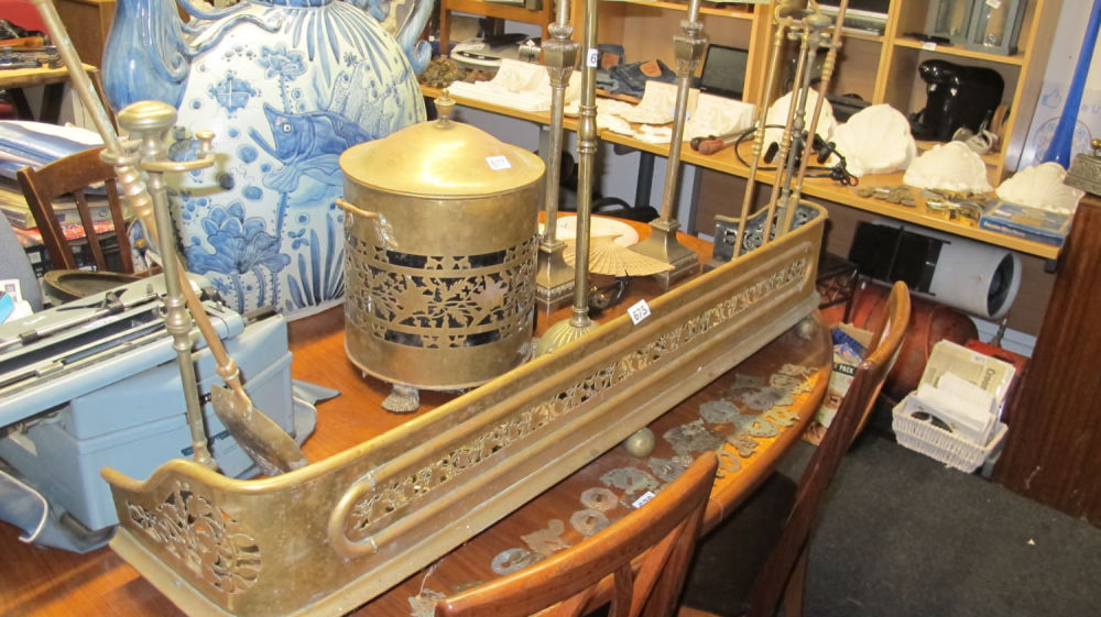 Lot 675: Large antique brass fire fender and tools