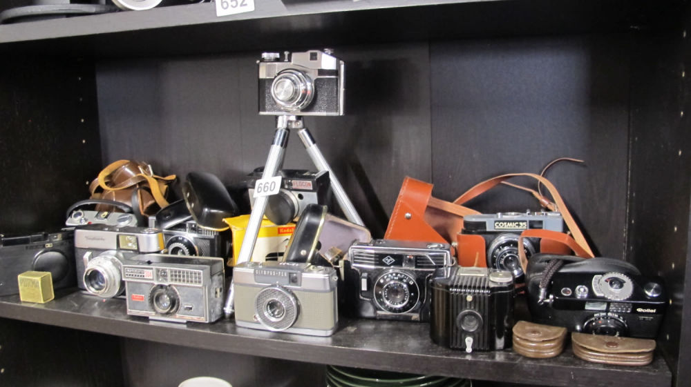 Lot 660: A shelf of cameras