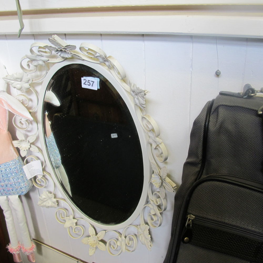 Lot 257: A decorative wall mirror with a metal floral...