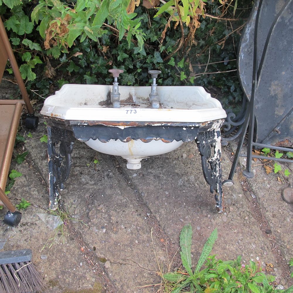Lot 773: Vintage porcelain corner sink with taps on cast...