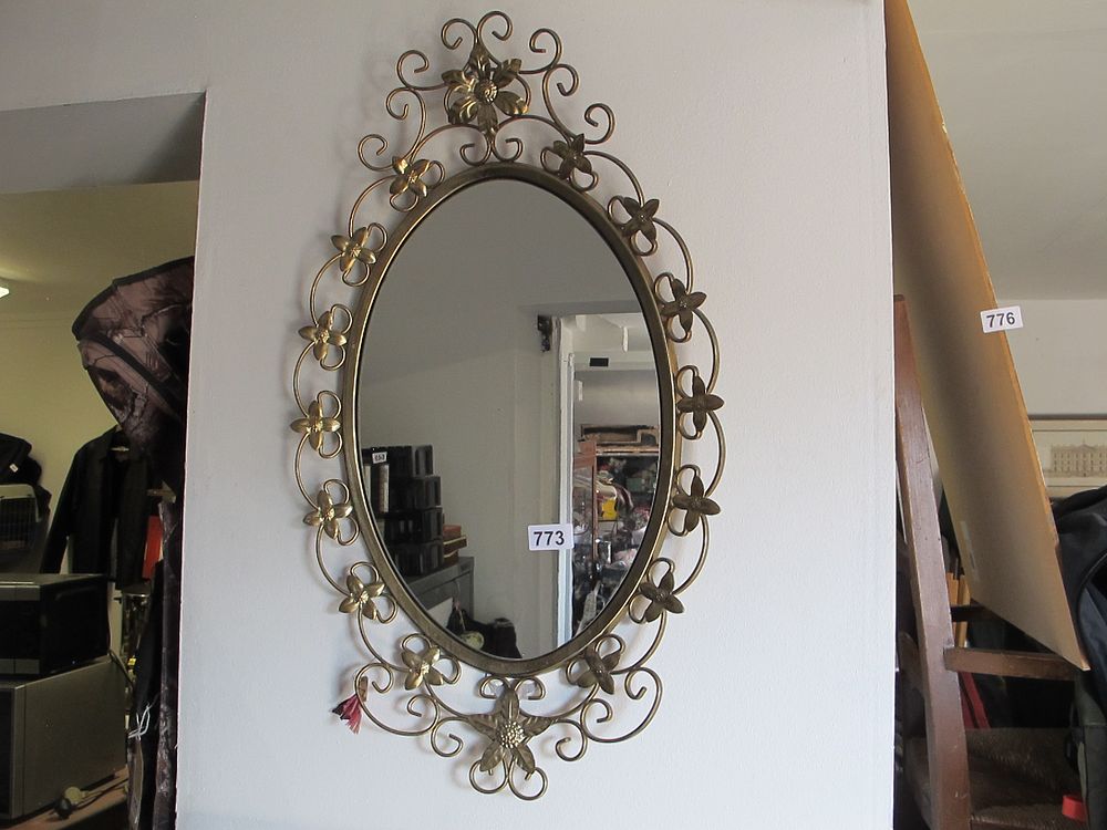 Lot 773: A Decorative Oval Wall Mirror with Brass-Toned Floral...