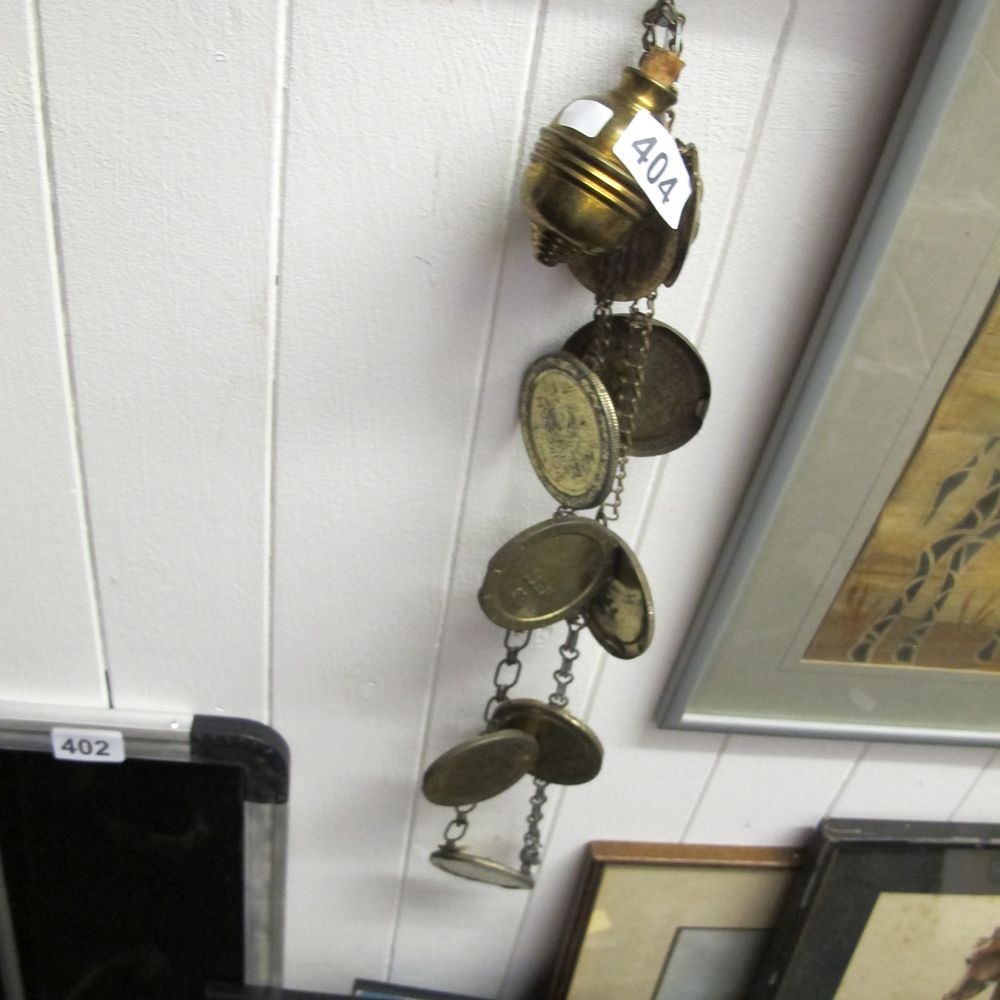 Lot 404: A Collection of Brass Tokens on a Decorative...
