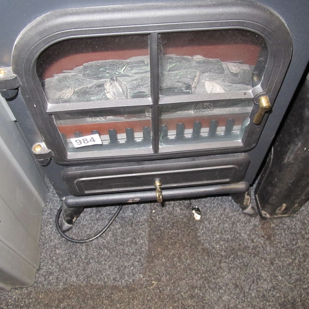 Lot 984: A contemporary freestanding electric log-effect stove heater in...