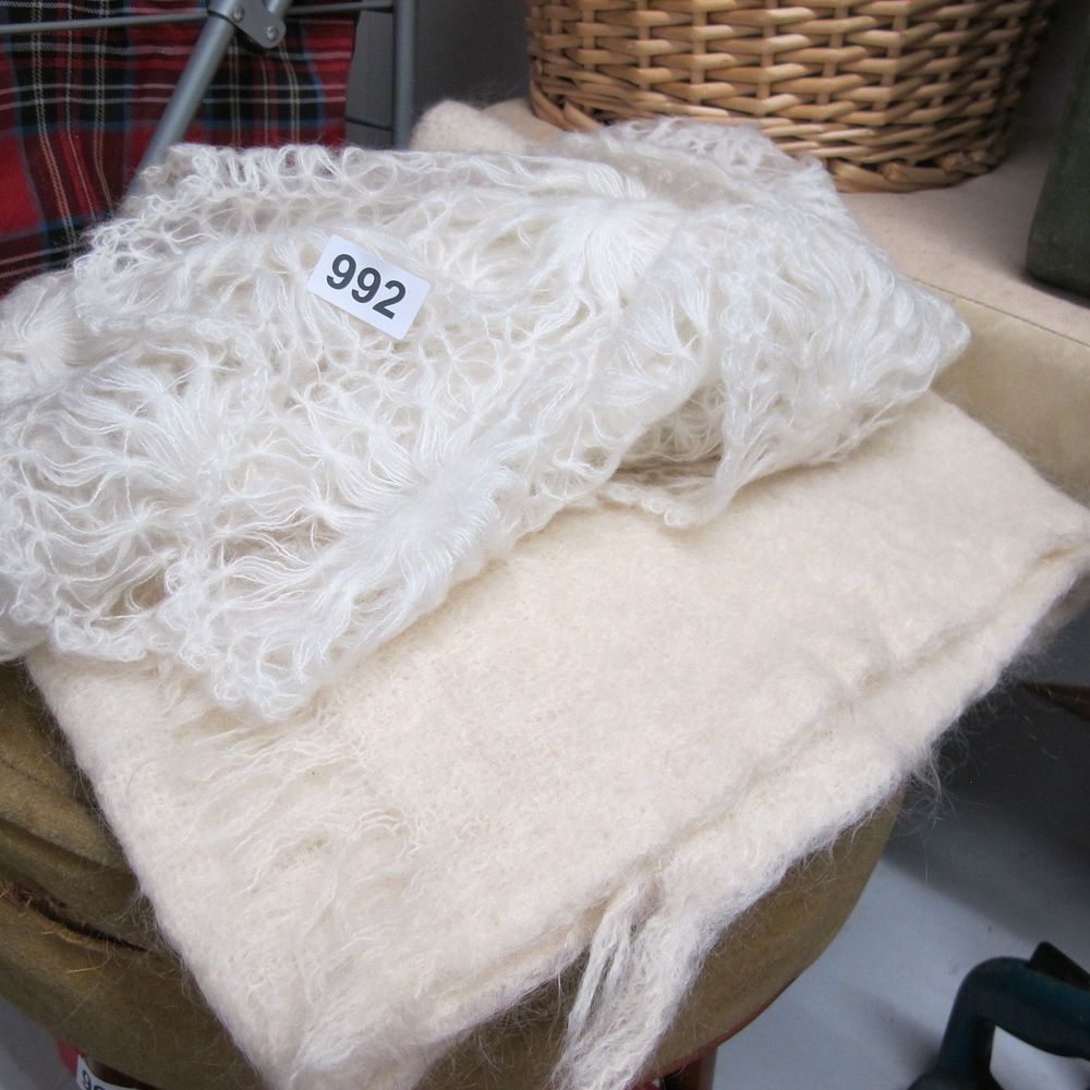Lot 992: Two cream wool-blend textiles comprising a lace-knit shawl...