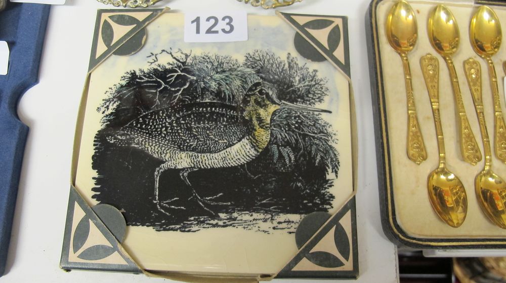 Lot 123: A Transfer Printed Ceramic Tile and a Cased Set of Gold Toned Spoons