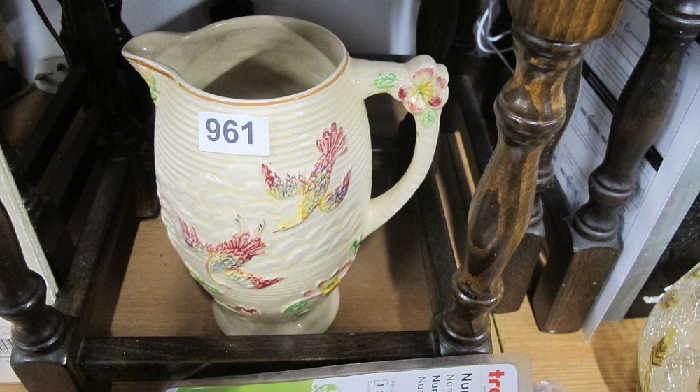 Lot 961: A relief-molded earthenware jug decorated with exotic birds