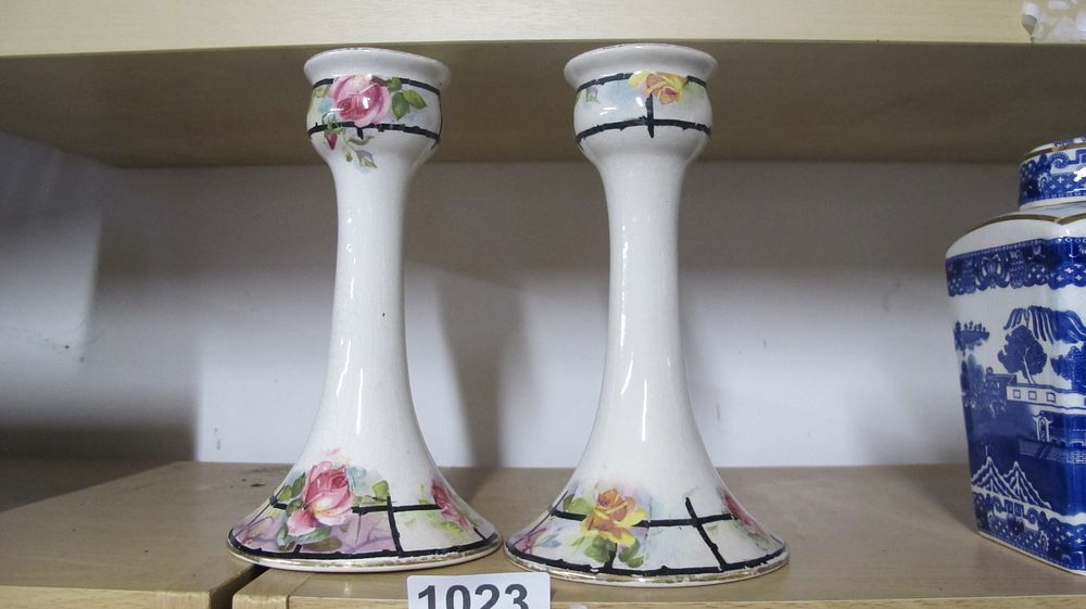 Lot 1023: A Pair of Earthenware Candlesticks with Hand Painted Rose Decoration