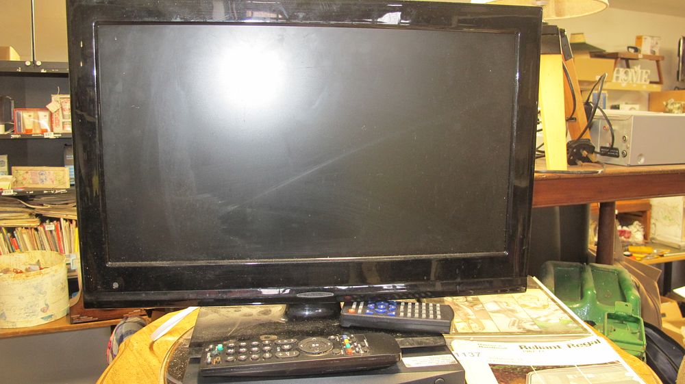 Lot 1136: A Black Flat Screen LCD Television with Two Remote Controls