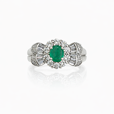 EMERALD AND DIAMOND RING. White gold ring with a 6x5 mm oval-cut emerald and 10 brilliant-cut 