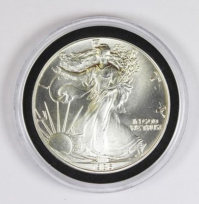 1986 AMERICAN SILVER EAGLE. SUPERB GEM BU. IN PLASTIC CAPSULE. ESTIMATE: $50-$75