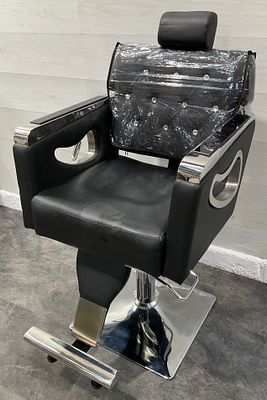 * A contemporary black upholstered hydraulic reclining salon chair with chrome accents. A 