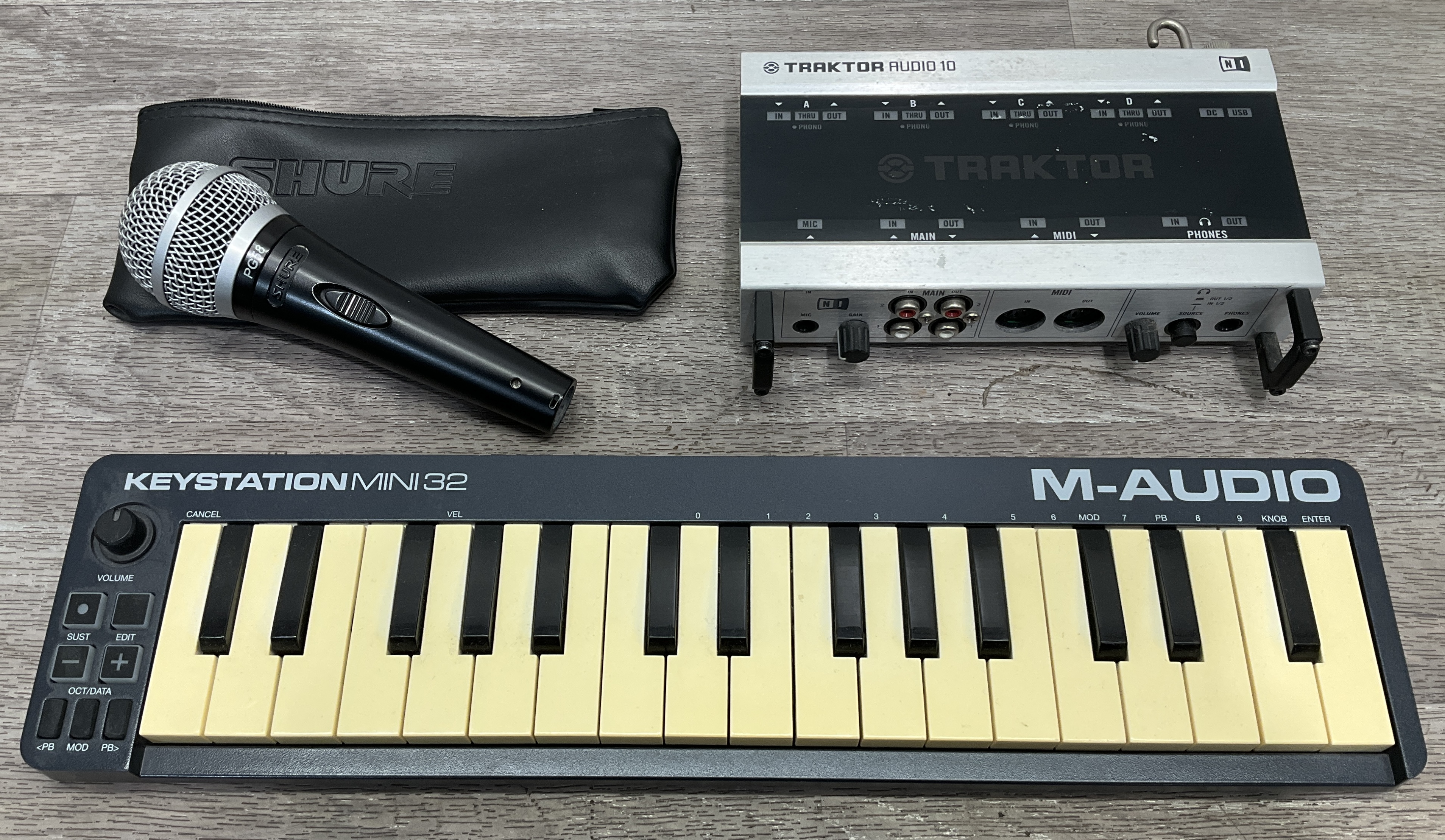 * A Carton Containing A Trio of Native Instruments, Shure, and M-Audio Music Production Equipment