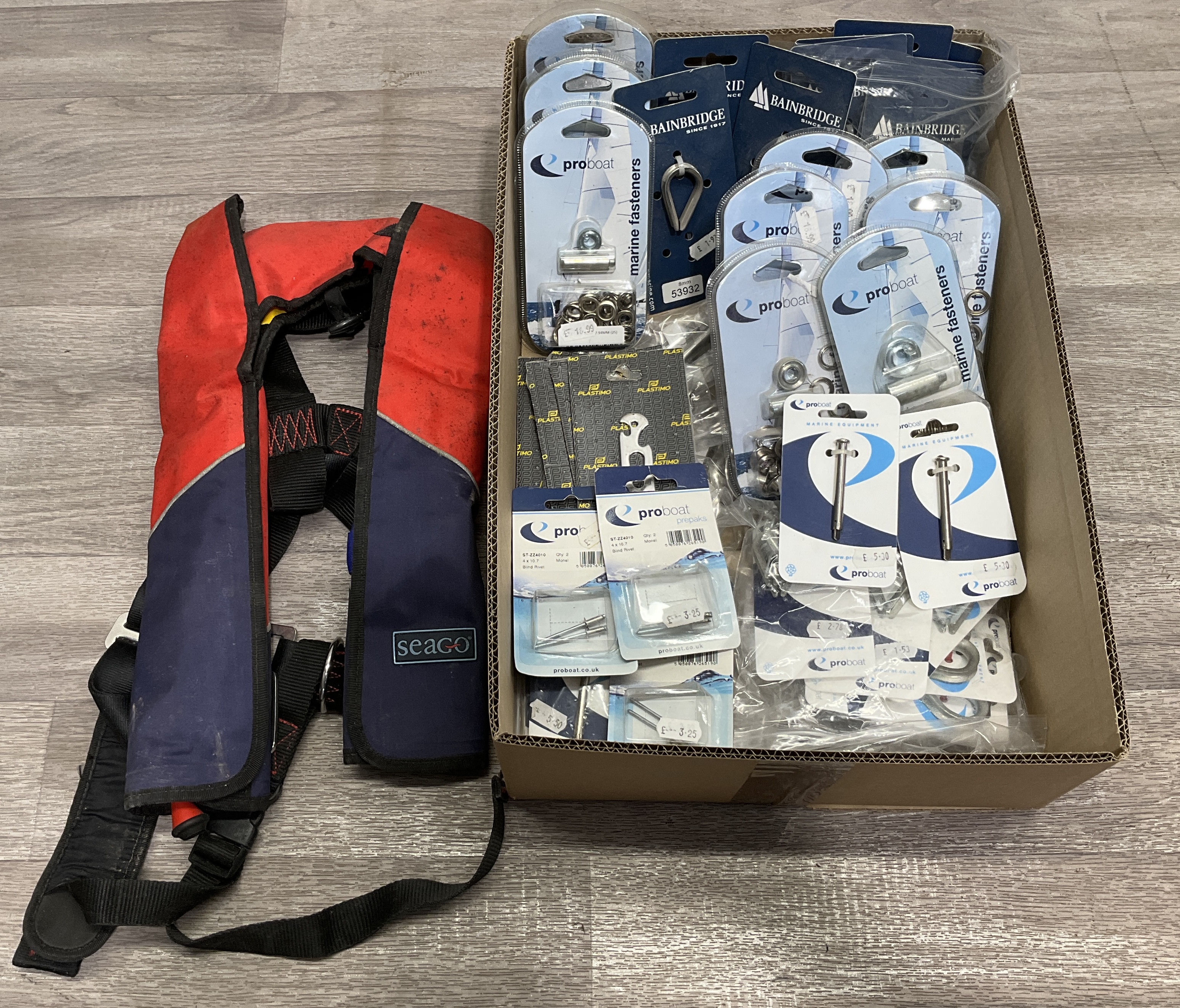 A Carton Containing A Seago 150N Inflatable Lifejacket and an Assortment of Marine Hardware and Fasteners