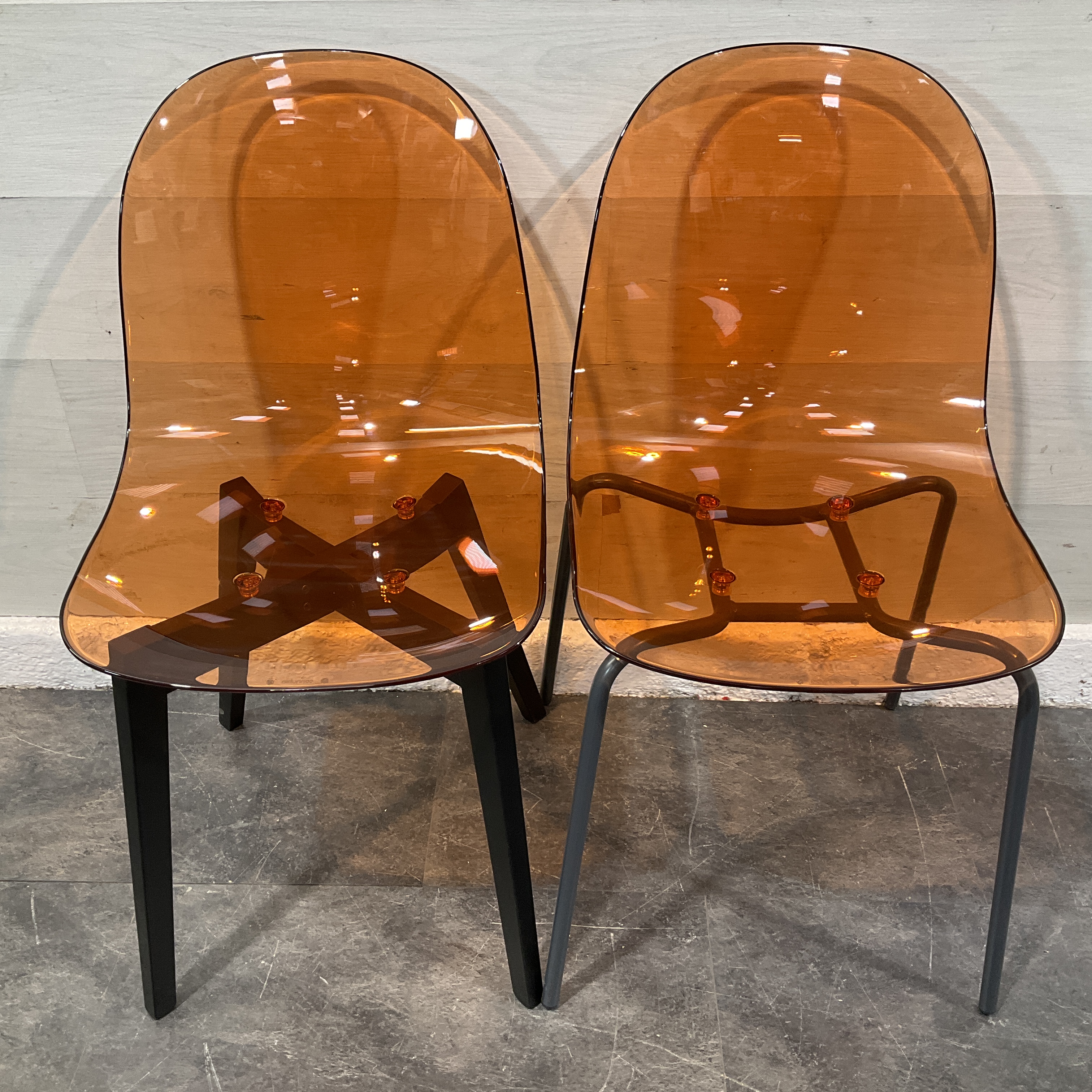 * A Pair of Connubia Academy Translucent Amber Polycarbonate Dining Chairs with Different Bases