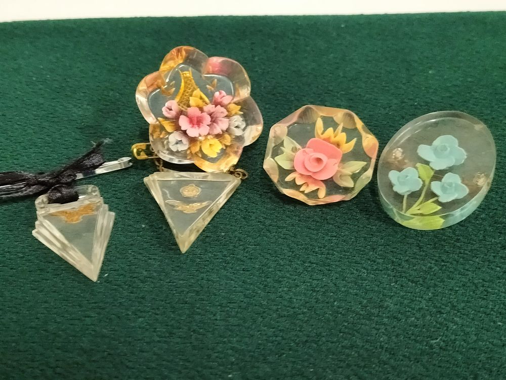 Lot 168 – Base metal and Lucite costume jewellery collection, reverse-carved floral and military motifs