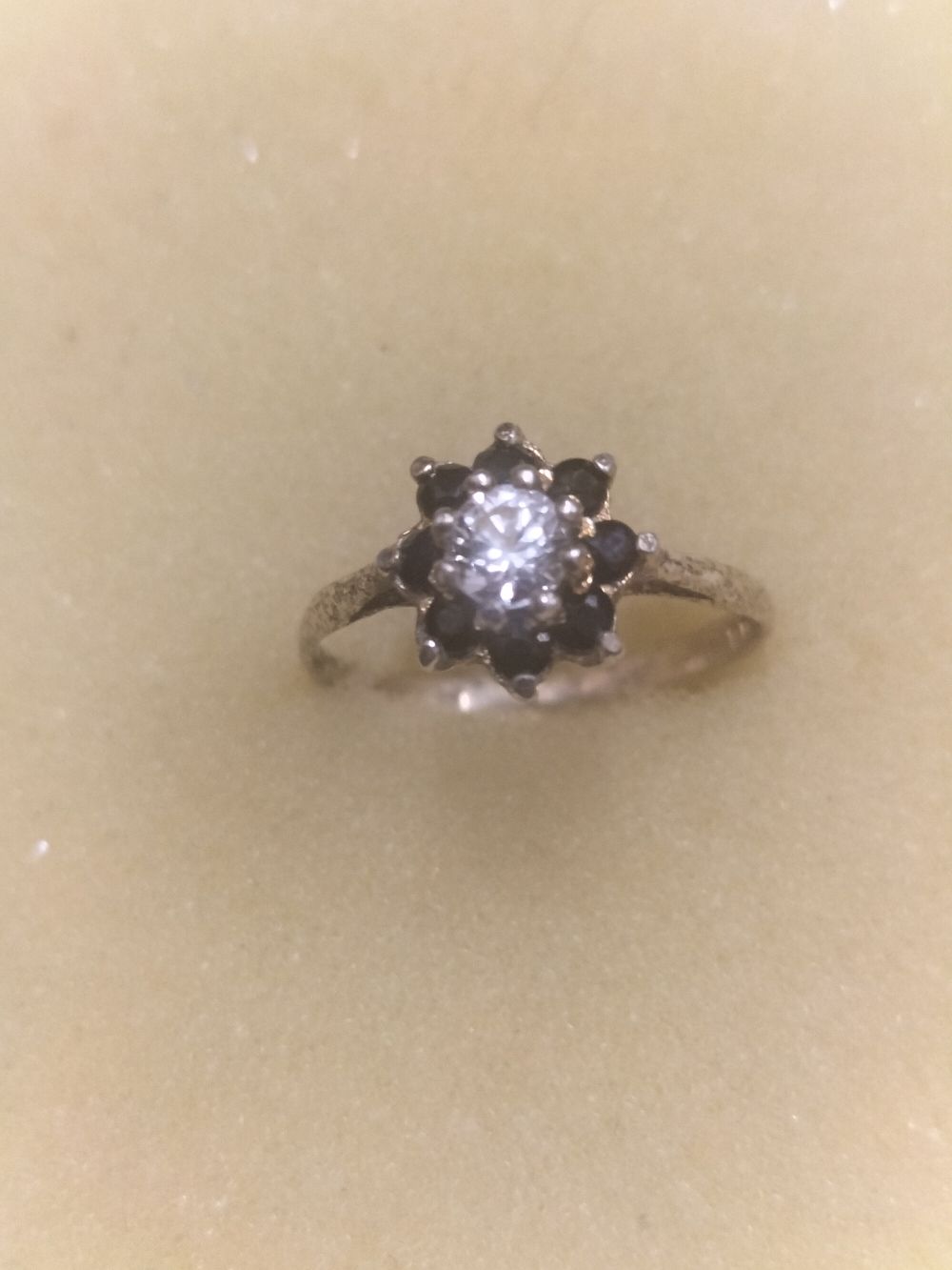 Lot 235 – White metal cluster ring featuring a central colourless stone and dark stone halo