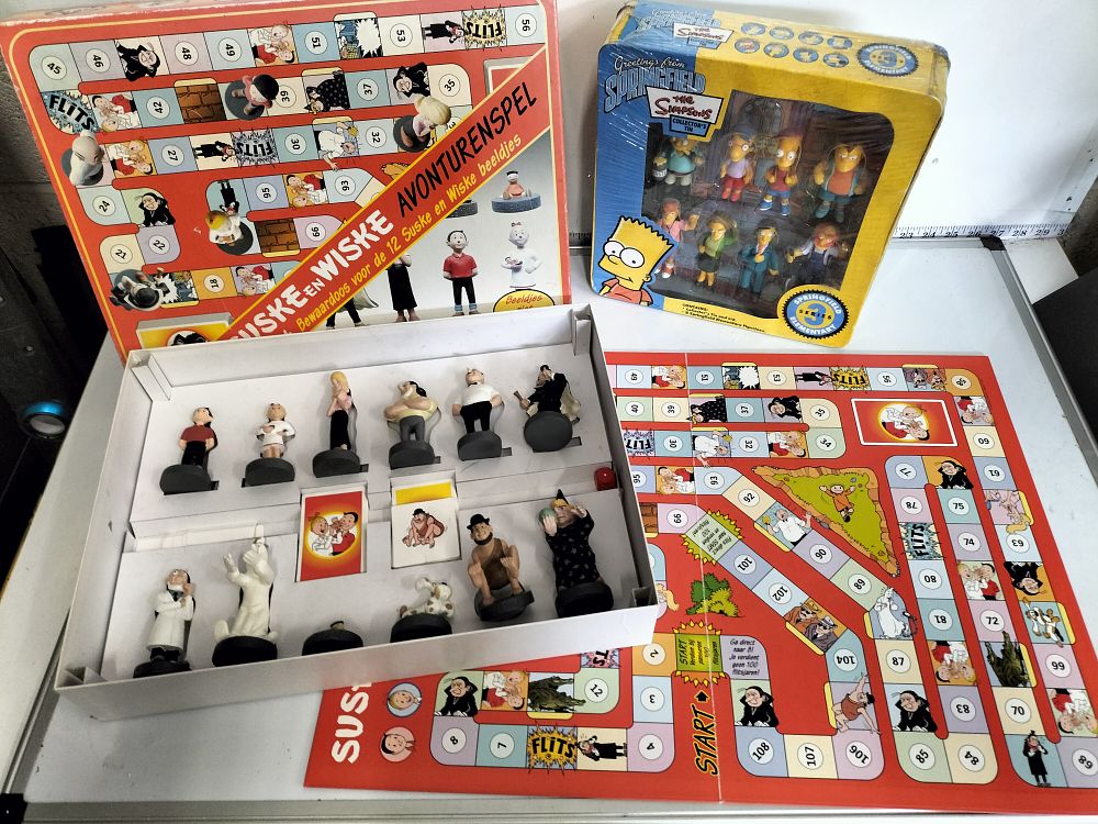 Lot 190 – Two Character Figurine and Game Sets comprising Suske en Wiske Avonturenspel and The Simpsons Greetings from Springfield Collector’s Tin