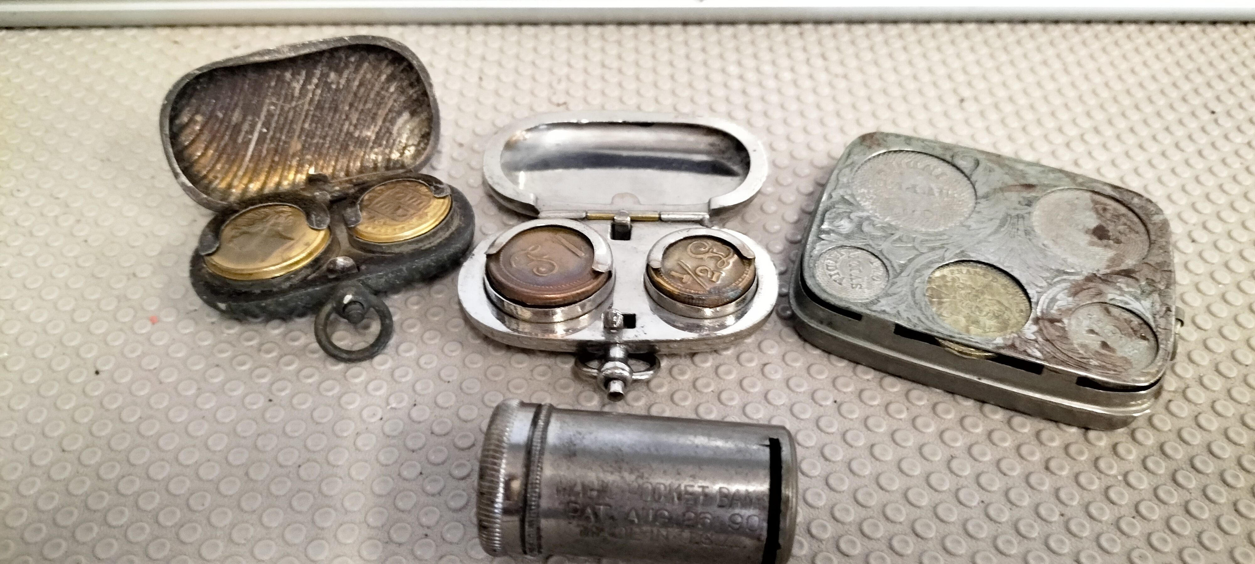 A Collection of Vintage Metal Coin Holders and an 1890 Magic Pocket Bank