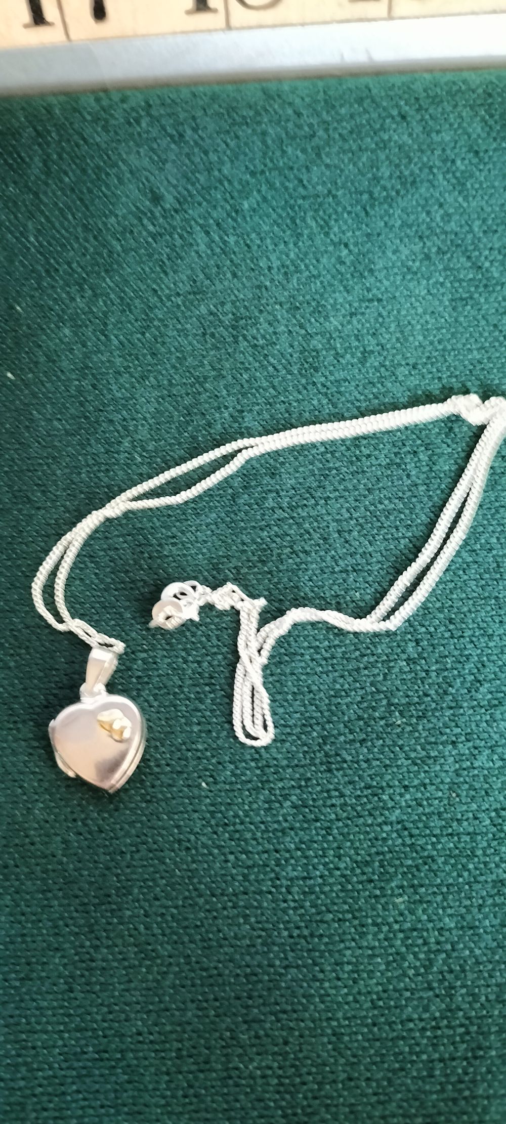 Lot 153 – A Silver Heart Locket Necklace with Gold Butterfly Accent