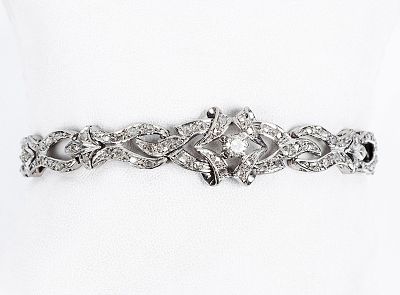 Brazalete antiguo en oro blanco 18 K, con un diamante, talla brillante, central, en garritas 
