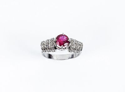 Sortija antigua en montura de platino con una piedra roja central, talla brillante, en garras 