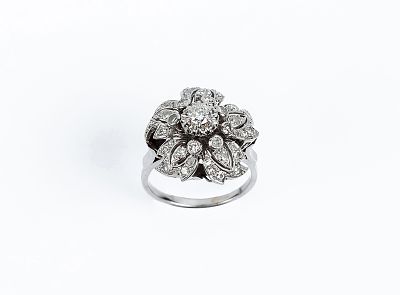 Sortija antigua en sólida montura de platino. Motivo en flor-rosetón con un limpio y blanco 