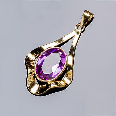 Colgante en oro amarillo 18 K, con motivo de lágrima calada, ondulada, con una piedra color 