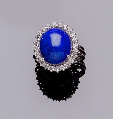 Sortija vintage en montura calada de oro blanco 18 K, con cabujón oval de lapislázuli, y orla 