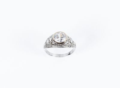 Bonito anillo vintage en montura de oro blanco 18 K, con circonita central en copa decorada con 