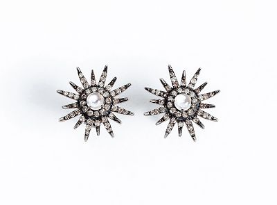 Pendientes en forma de estrella, con centro en cabuch&oacute;n de cuarzo opalino, orla y 'rayos' en 