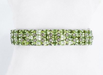 Brazalete esclavo en plata de ley, con frente cuajado de peridotos ovales, en garras. Cierre de 