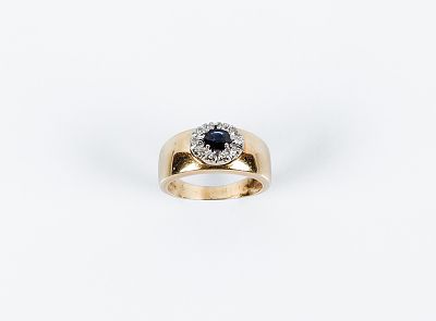 Anillo en oro amarillo 18 K con centro en roset&oacute;n de zafiro fino azul oval y orla en fila de 