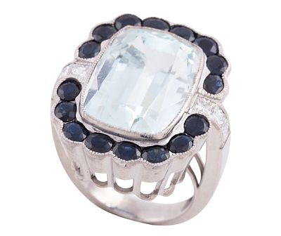 SORTIJA DE C&Oacute;CTEL EN ORO DE 18 KT. GRAN AGUAMARINA 19.42 CT. ZAFIROS Y DIAMANTES. Sortija de 