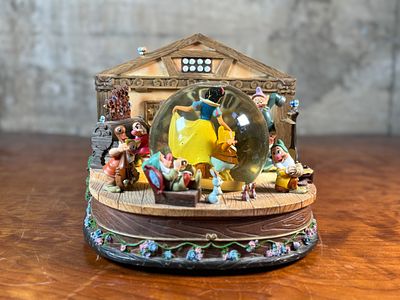 DISNEY STORE, "SNOW WHITE AND THE SEVEN DWARFS" MUSICAL SNOW GLOBE. This lot features a rare 