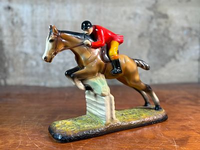 ALEXANDER BACKER COMPANY, JOCKEY ON A HORSE SCULPTURE. This lot features a sculpture of a jockey 