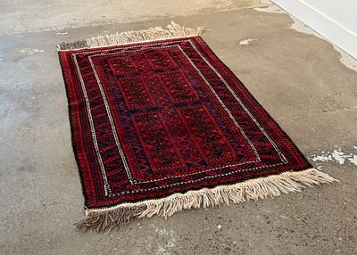HAND-KNOTTED BALUCH RUG. This lot features a stunning antique hand-knotted Baluch rug that 