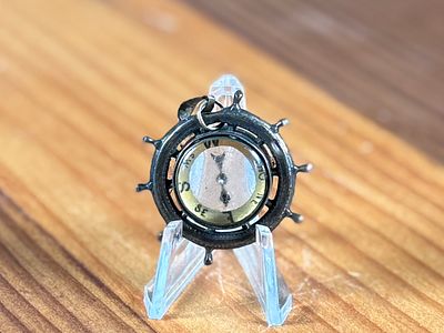SHIP'S WHEEL COMPASS PENDANT. This lot features an antique ship's wheel compass pendant.
