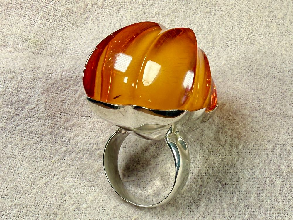 MONUMENTAL STERLING SILVER & AMBER RING. Sterling silver ring featuring a large, polished amber 