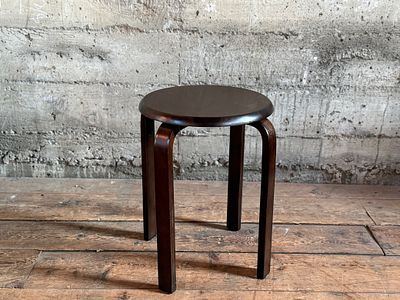 ROUND WOODEN STOOL. This lot features a modern wood stool in the style of the iconic Artek Stool 
