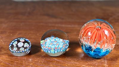 THREE GLASS PAPERWEIGHTS. Three glass paperweights featuring intricate floral and abstract 