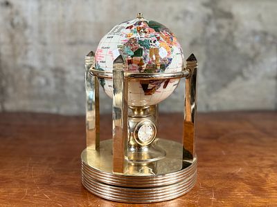 ROTATING GEMSTONE GLOBE. This lot features a vintage rotating gemstone globe set in a brass 