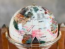 ROTATING GEMSTONE GLOBE. This lot features a vintage rotating gemstone globe set in a brass Image - 1