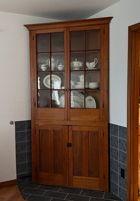 CHERRY CORNER CUPBOARD. This lot features an antique cherry corner cupboard with a distinctive 