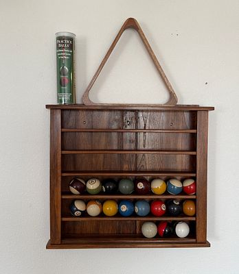 WOODEN POOL BALL RACK. This lot features an antique wooden pool ball rack with a collection of 